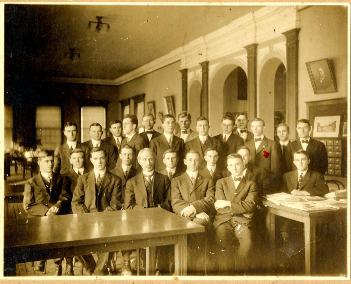 President Snyder poses with students in the original library. Snyder is the president who encouraged the changes in admission standards beginning in 1908. 