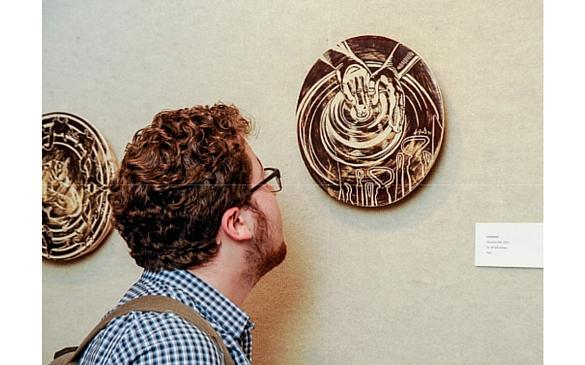 A student admires a piece of art during Carolyn Ford’s display of her “Discombobulation” pottery series and art talk that Wofford hosted.  Photo credit: Mark Olencki.