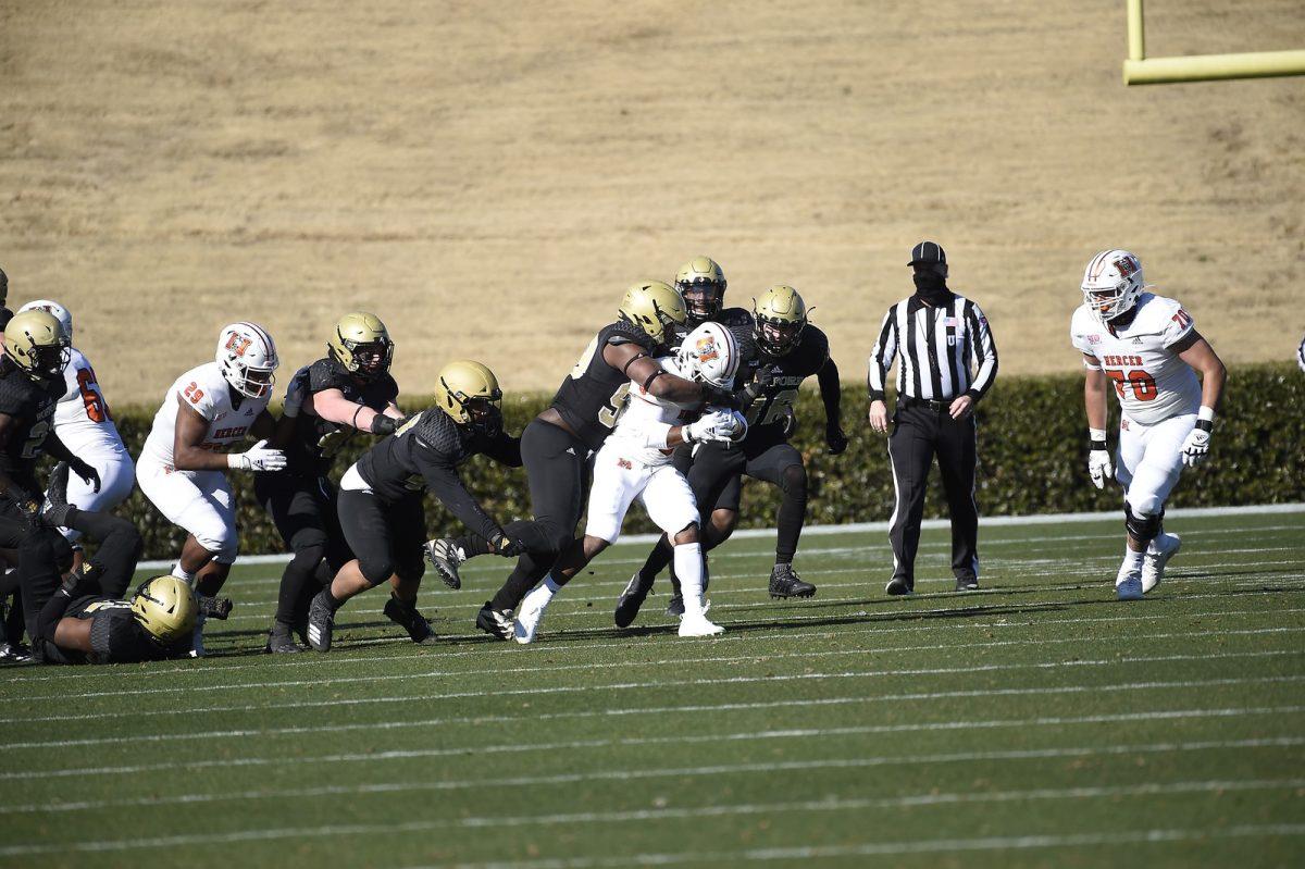 Defensive lineman Micheal  Mason (#99) tackles a Mercer ball carrier. Mason led the Wofford defensive effort with two forced fumbles and nine tackles. Photo courtesy of Mark Olencki.