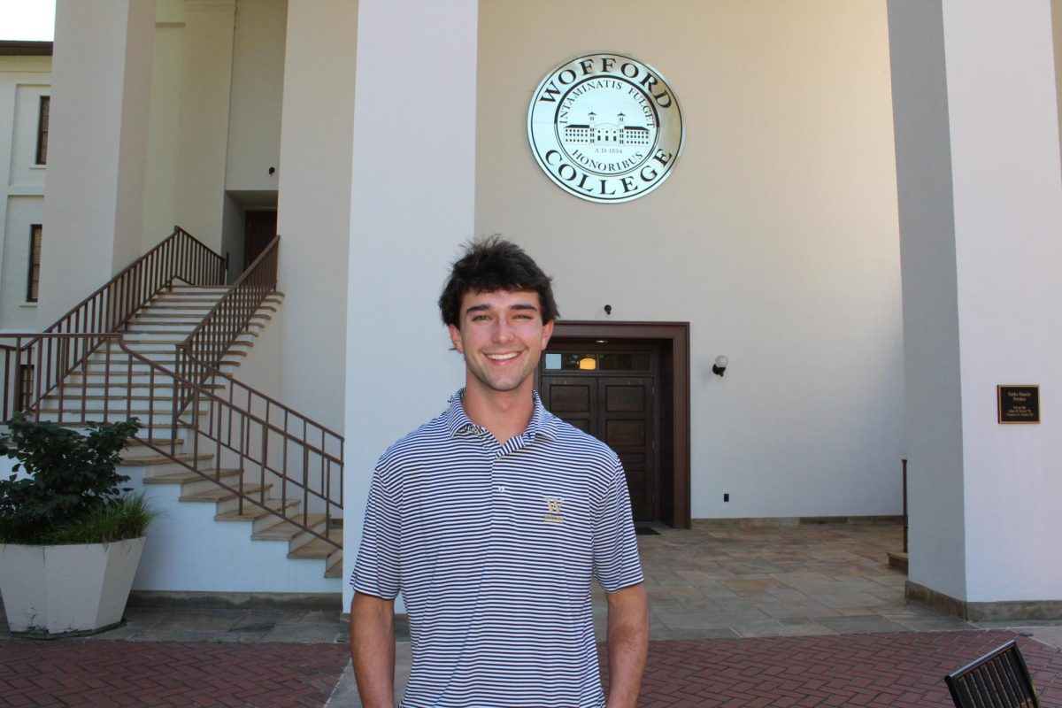 Davis Young ‘25 poses in front of the Old Main building. Young’s father spent three decades working for Wofford’s basketball program.